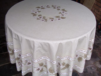 Protective coated round beige tablecloth sunflower design